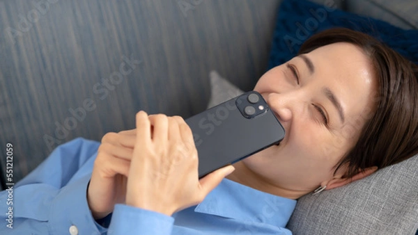 Fototapeta 笑顔でスマホを持つ女性