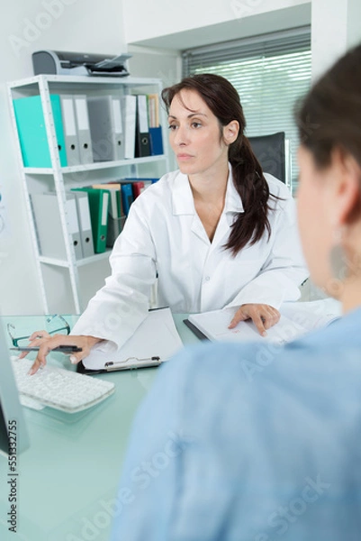 Fototapeta female doctor talking with patient in office