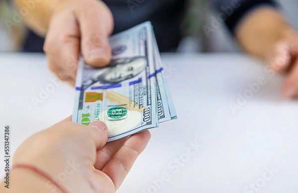 Fototapeta Man gives hands money dollars. Selective focus.