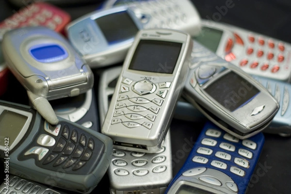 Fototapeta silver cellular phone on top of pile.