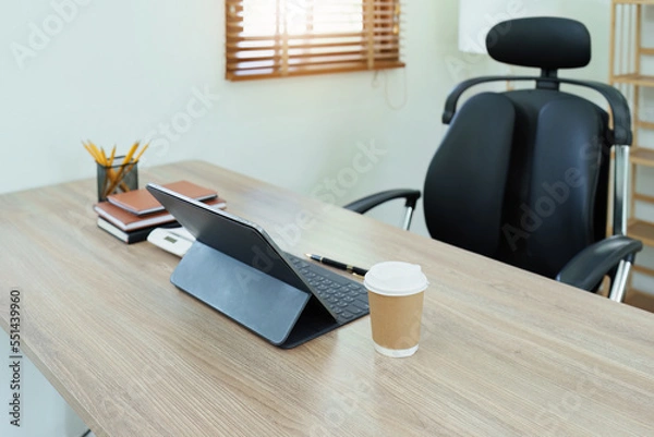 Fototapeta Tablet computer, notebook, calculator and coffee cup on the desk in the office