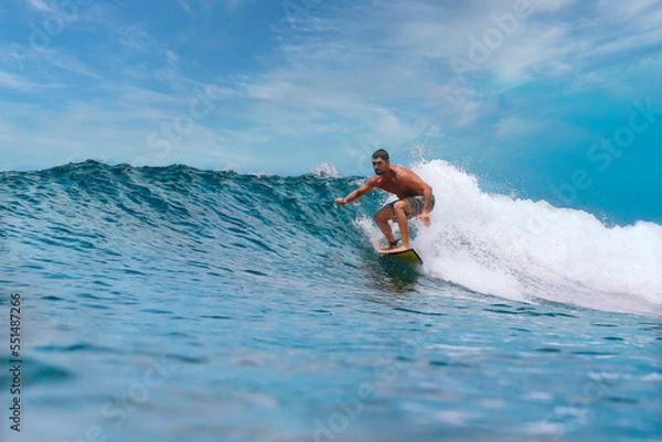 Fototapeta Shirtless male surfer on a wave at sunny day