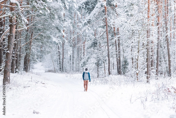 Fototapeta man walking alone in a beautiful snowy forest. Mental health concept