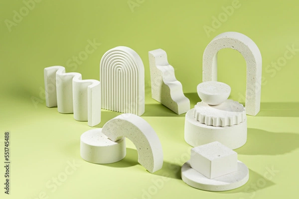 Fototapeta An empty stage with a composition of white podiums of different sizes and shapes on a green background and shadows