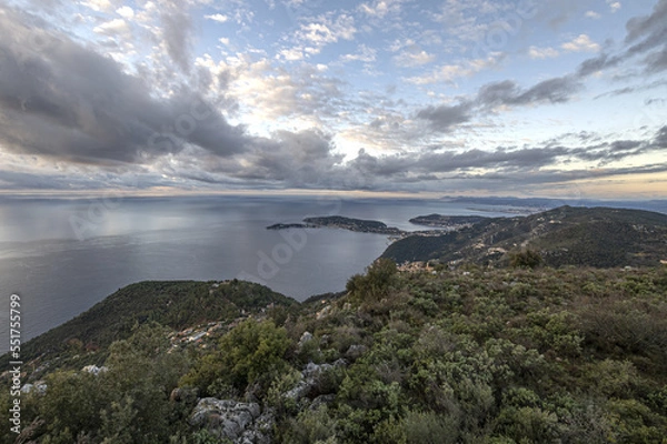 Fototapeta Panorama en bord de mer sur la Côte d'Azur avec comme paysage un ciel menaçant et un coucher de soleil et des falaises