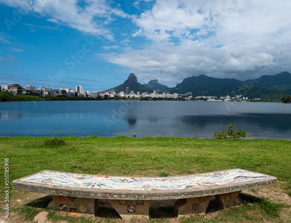 Fototapeta A mosaic bench, inspired by Park Güell in Barcelona, in front of the Lagoa Rodrigo de Freitas in Rio de Janeiro. Dos Hermanos mountains in background.