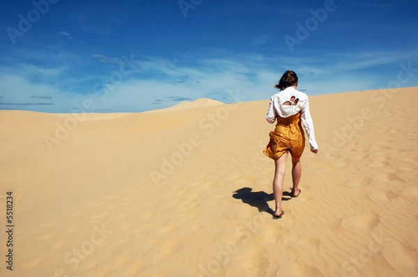 Fototapeta a girl walking in sand dunes