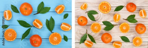 Fototapeta orange or tangerine with leaves on blue wooden background. Flat lay, top view. Fruit composition