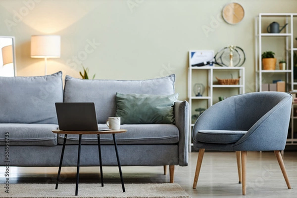 Fototapeta Background image of comfortable and stylish blue-gray furniture in minimal living room interior with laptop on coffee table, copy space