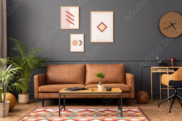 Fototapeta Modern living room interior with mock up poster frame, brown sofa, wooden coffee table, patterned rug,  round clock, plants, beige curtain, desk and personal accessories. Home decor. Template.