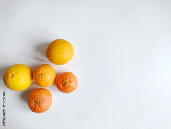 Fototapeta Oranges and tangerines on white background. Top view, flat lay. Autumnal first fruits and seasonal concept.