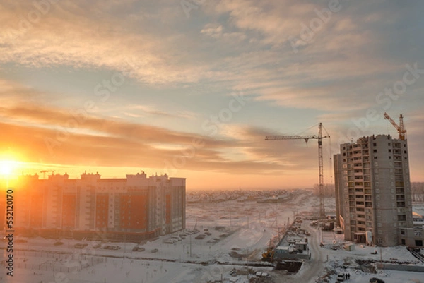 Fototapeta Construction of multi-storey residential buildings at dawn in winter