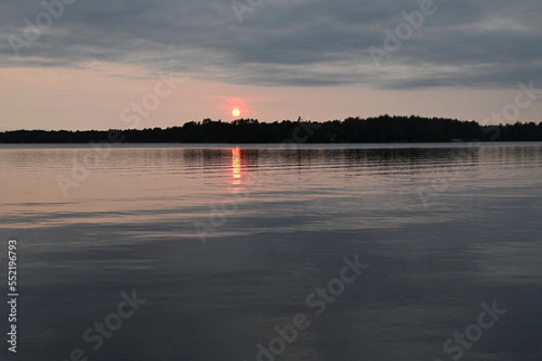 Obraz Early evening on a lake with wind blown clouds