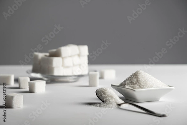 Obraz Natural sweetener in a wooden spoon. Sugar substitute. Erythritol. High quality photo. Photo of sugar on a white background, with copy space