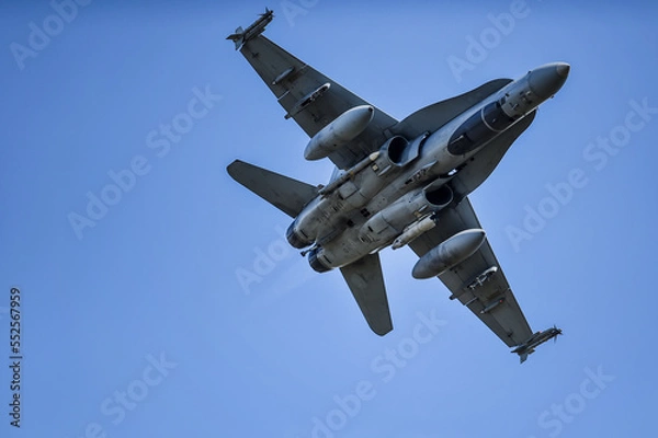 Fototapeta Military supersonic fighter jet with blue sky in the background