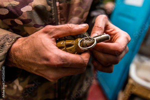 Obraz a grenade in a man's hand. Military man holding explosives