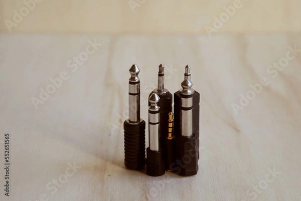 Fototapeta Set of audio jack adapter 6,3 mm and 3,5 mm on a wooden bench. Close up. Audio technology concept.