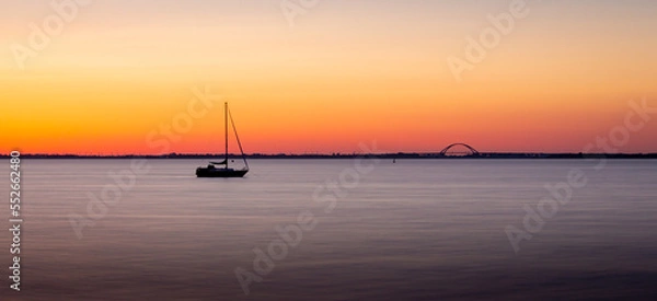 Obraz Segelschiff in der Ferne bei Sonnenaufgang 