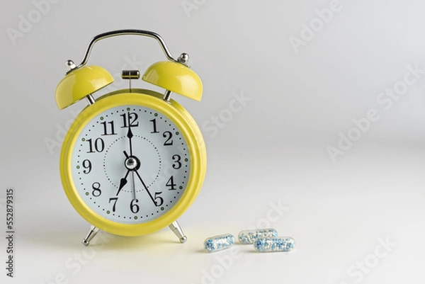 Obraz alarm clock on a light background with pills