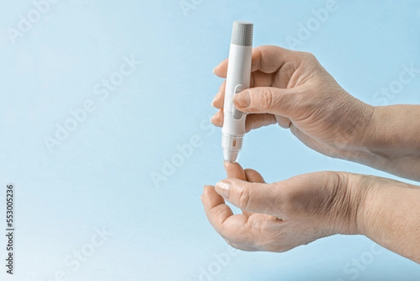Obraz Close-up Of elderly woman Hand Holding Sugar Level Checking Machine