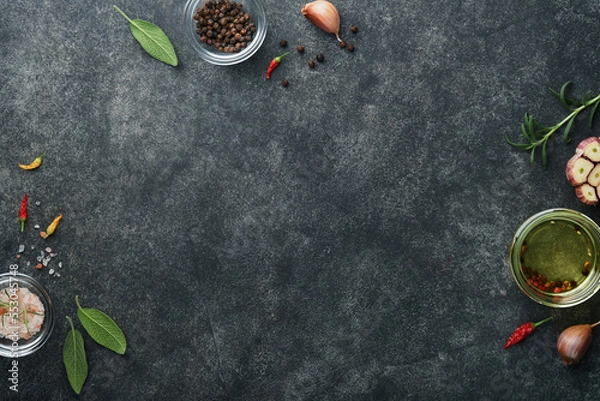Obraz Food cooking background. Green rosemary branches, olive oil, garlic, peppercorns and hot peppers at dark slate concrete table. Food ingredients top view.