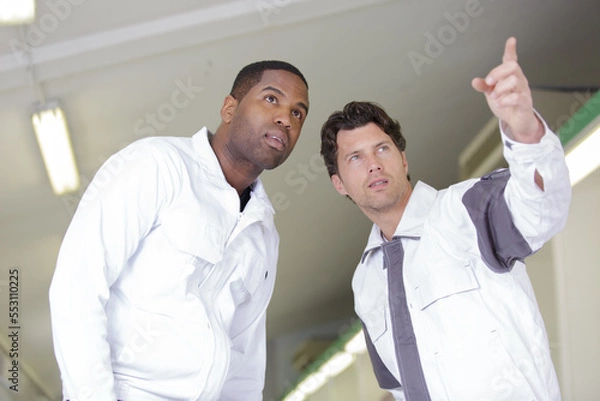 Fototapeta two painters pointing at something