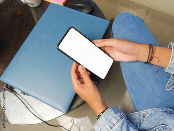 Obraz Close-up of a woman hand holding a smartphone white screen is blank .Mockup.