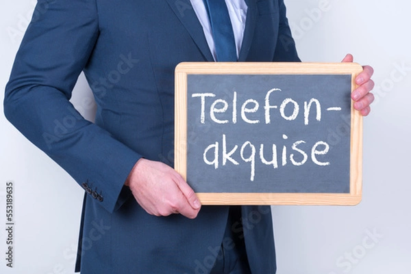 Obraz Vertriebsmitarbeiter mit einer Tafel auf der Telefonakquise steht