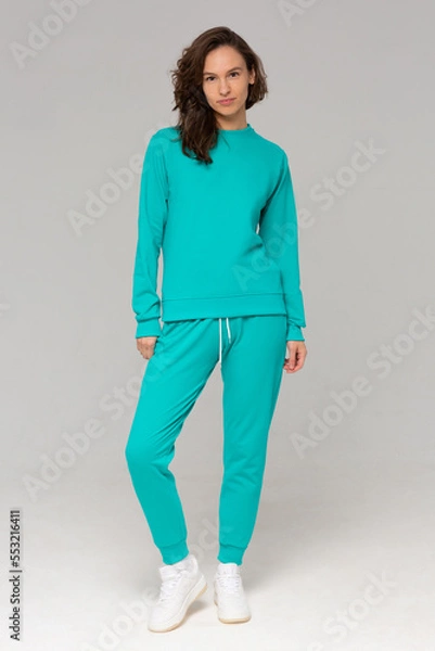 Obraz Smiling woman with thick curly hair in a mint suit of hoodies and sweatpants. Mock-up.