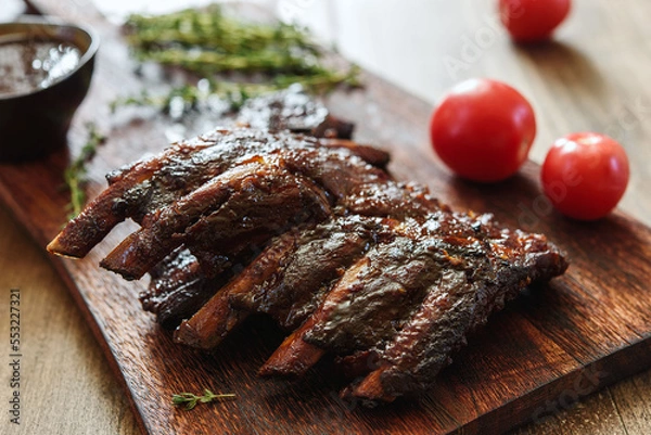 Fototapeta BBQ grilled pork ribs in Barbecue sauce on vintage wooden table background. Barbecue Pork Spare Ribs. Tasty snack to beer. American food concept. Selective focus