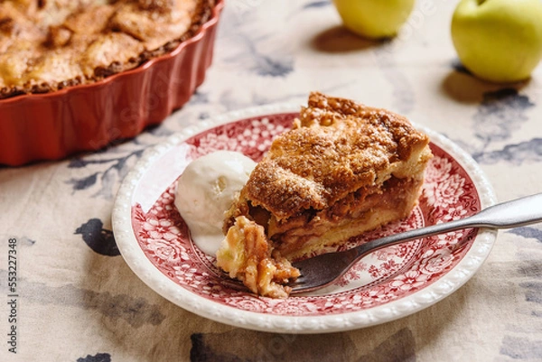 Fototapeta Classic American apple pie served with ice cream on linen tablecloth. Homemade american autumn dessert: sliced apple pie (tart) with cinnamon. Selective focus