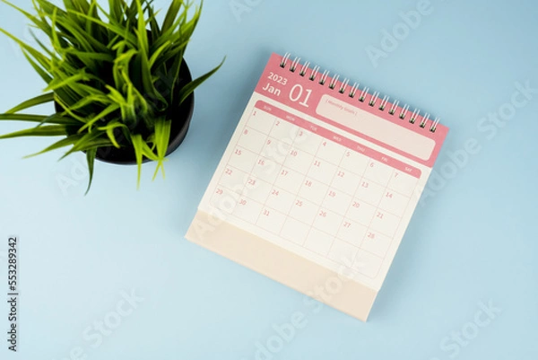 Fototapeta January 2023 desk calendar on blue background flay lay