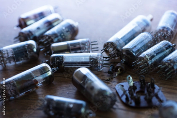 Fototapeta 50's 60's vacuum tube or valves on old wooden table with incoming light. Shallow depth of field.