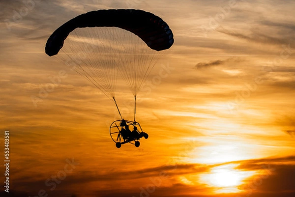 Obraz Powered paraglider in sunset