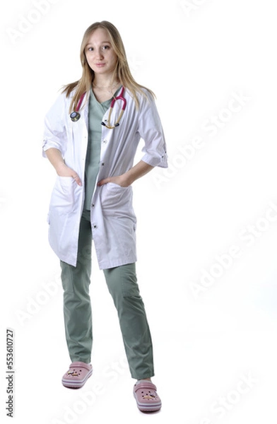 Fototapeta Full length portrait of the female physician in medical uniform with stethoscope isolated on white
