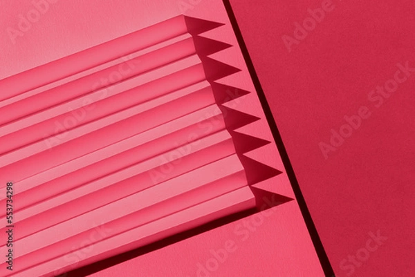 Fototapeta Viva Magenta color of the year 2023. Abstract crimson red color  paper texture. Folded paper with harsh sun shadows, geometric shapes and lines.