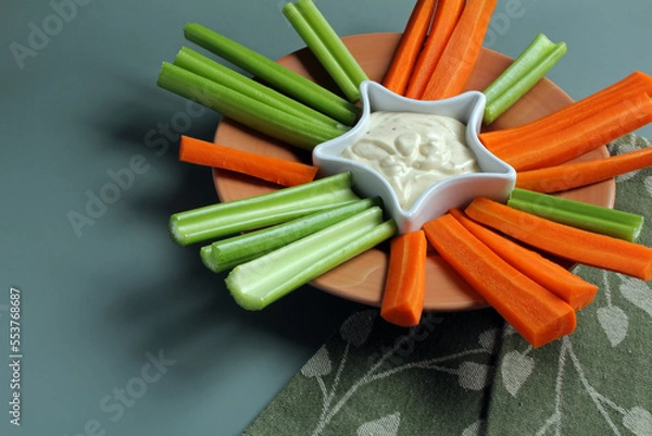 Obraz Crudités: celery and carrot sticks with creamy ranch dip.