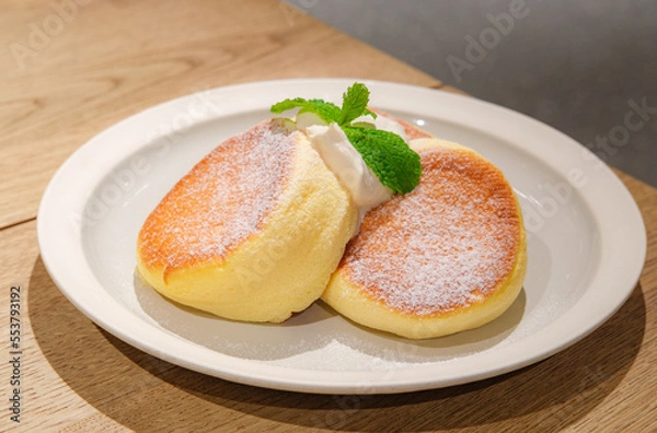 Obraz Japanese style sluffy souffle pancake dessert with cream served on a white plate on a wooden table