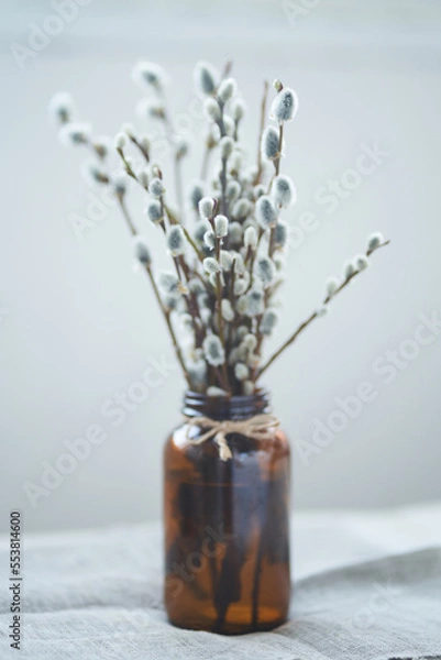 Fototapeta A bouquet of willow on the edge of the table. Willow, fluffy buds, brown glass vase. Happy Easter concept with copy space. High quality photo