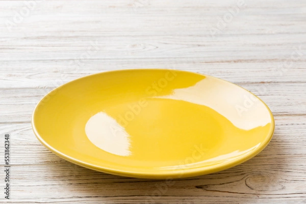 Obraz Perspective view of empty yellow plate on cement background. Empty space for your design