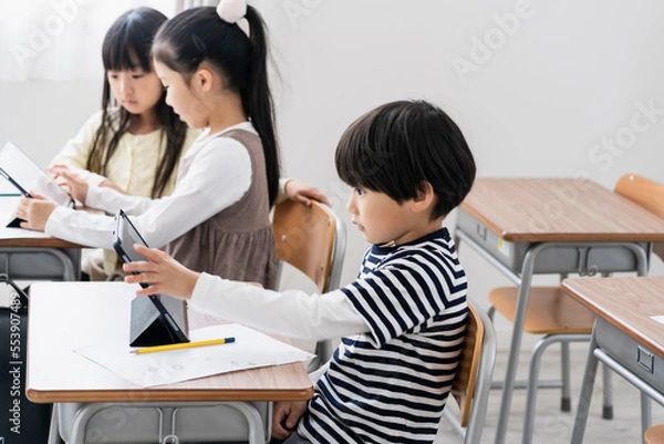 Fototapeta 教室でタブレットPCを見る日本人小学生