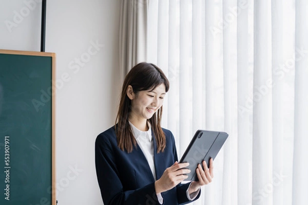 Fototapeta タブレットPCを見るスーツ姿の日本人女性