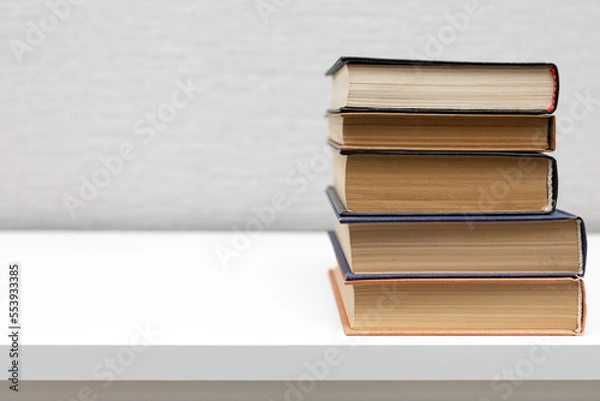 Fototapeta a stack of old books lies on the table.