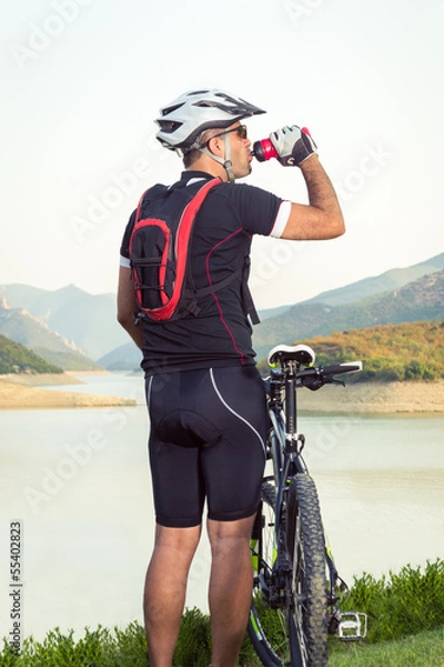 Fototapeta Mountain biker beside a beautiful lake