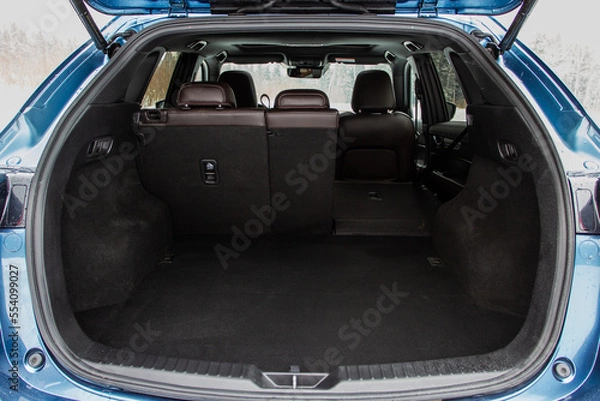 Fototapeta Huge, clean and empty car trunk in interior of compact suv. Rear view of a SUV car with open trunk