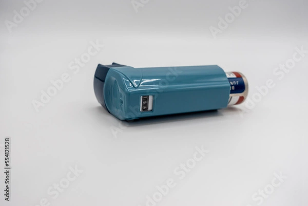 Fototapeta Selective focus on a blue inhaler on a white background