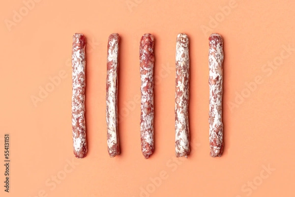 Fototapeta Flat lay of mini fuet snack sticks on the beige background
