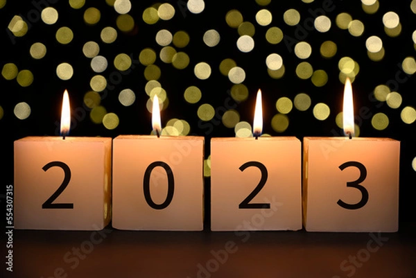 Fototapeta Candles with 2023 numbers. Concept of Happy new year with bokeh background.