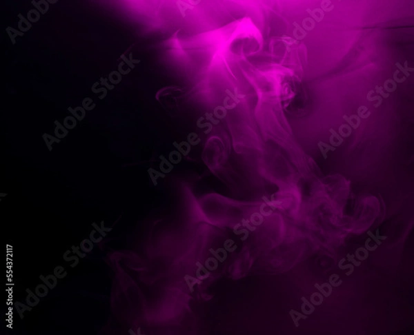 Fototapeta Abstract background of chaotically mixing puffs of purple smoke on a dark background