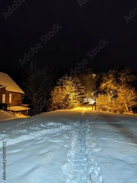 Obraz house with lights in the windows and snow everything around 